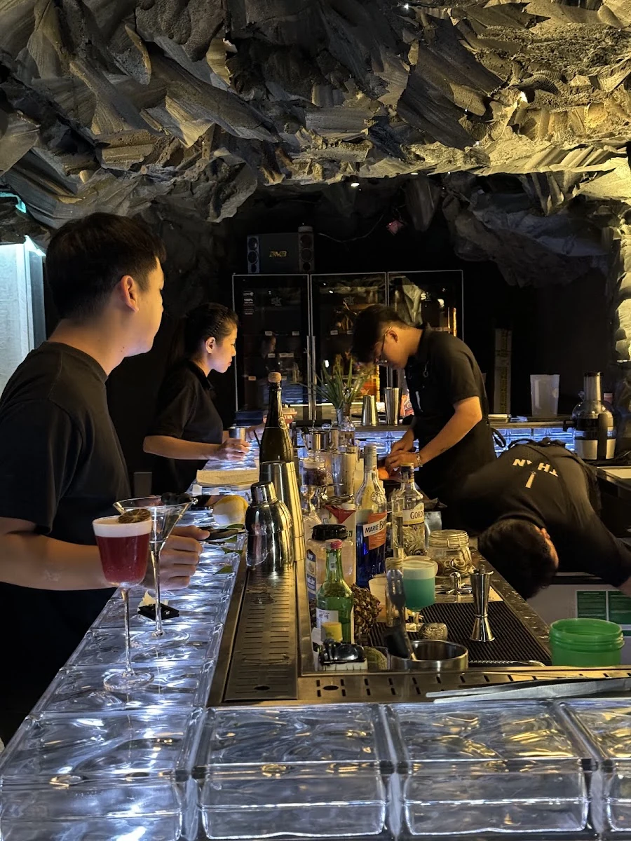 Bartenders working behind the blue glass-block bar
